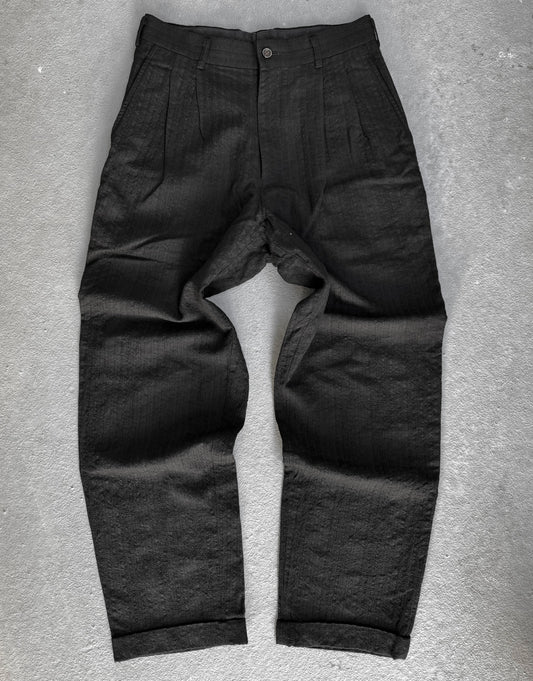 Dark gray pants on a textured gray surface