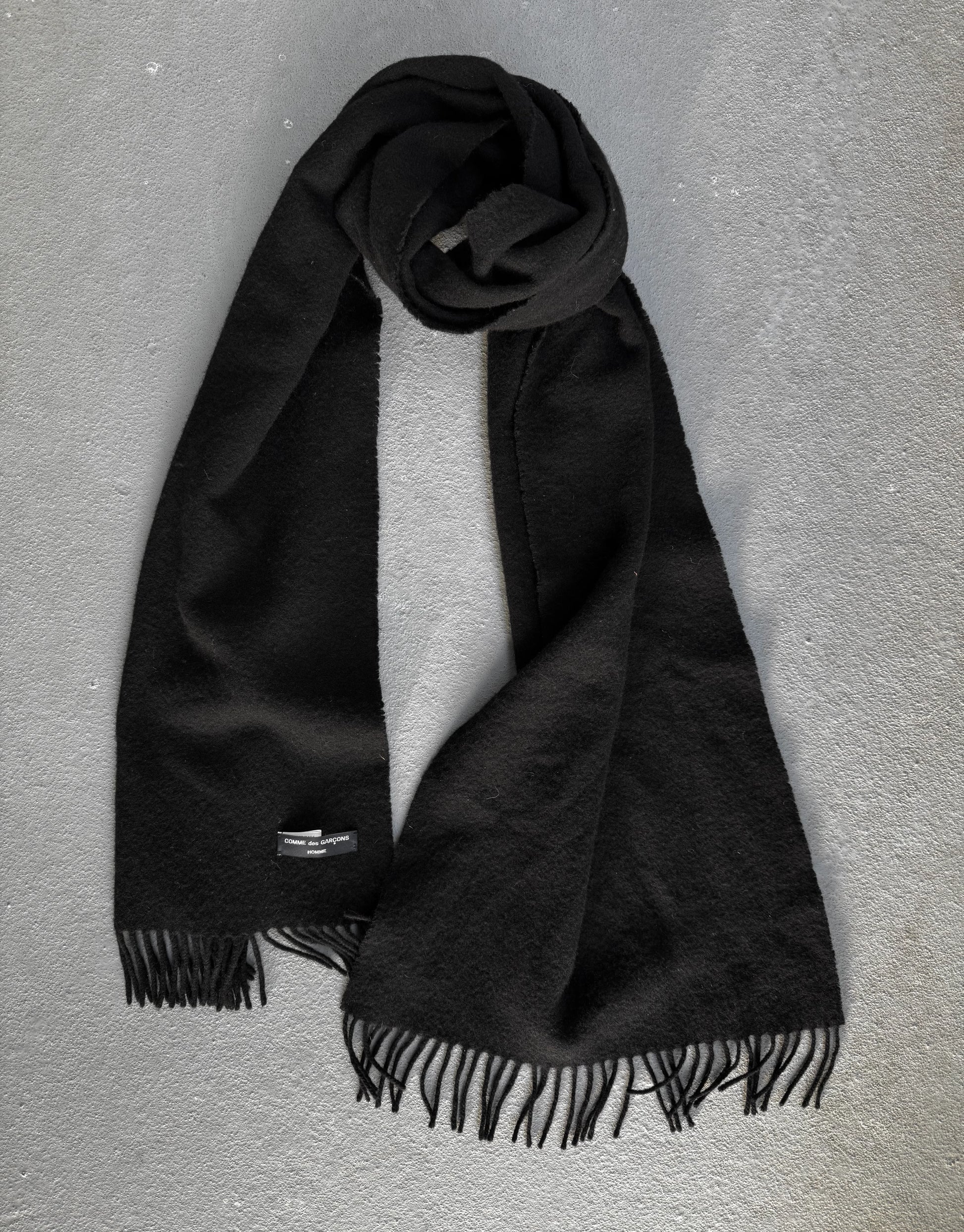 Black scarf with fringes on a gray background