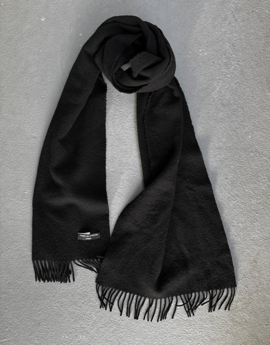 Black scarf with fringes on a gray background