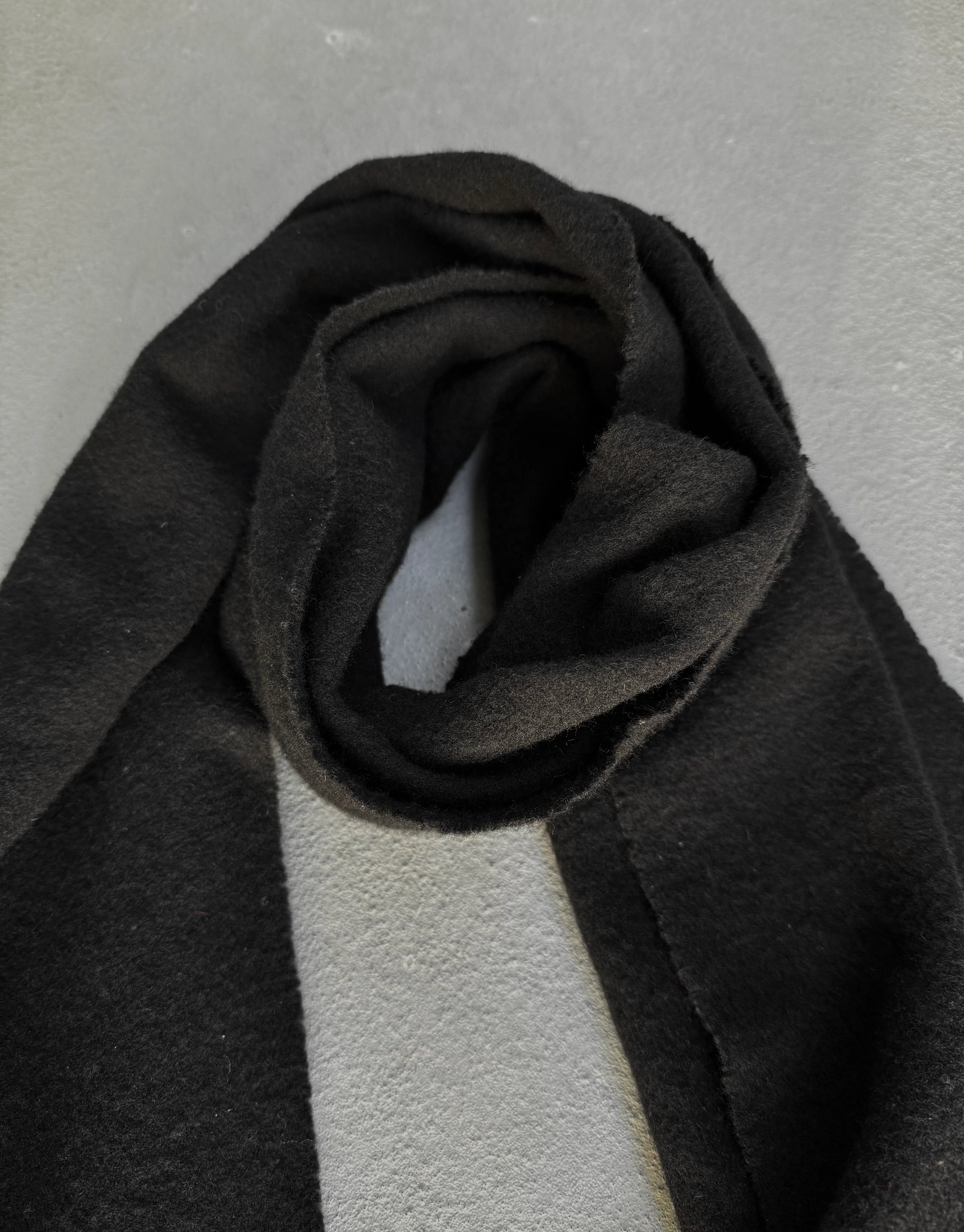 Dark gray fabric roll on a light gray background