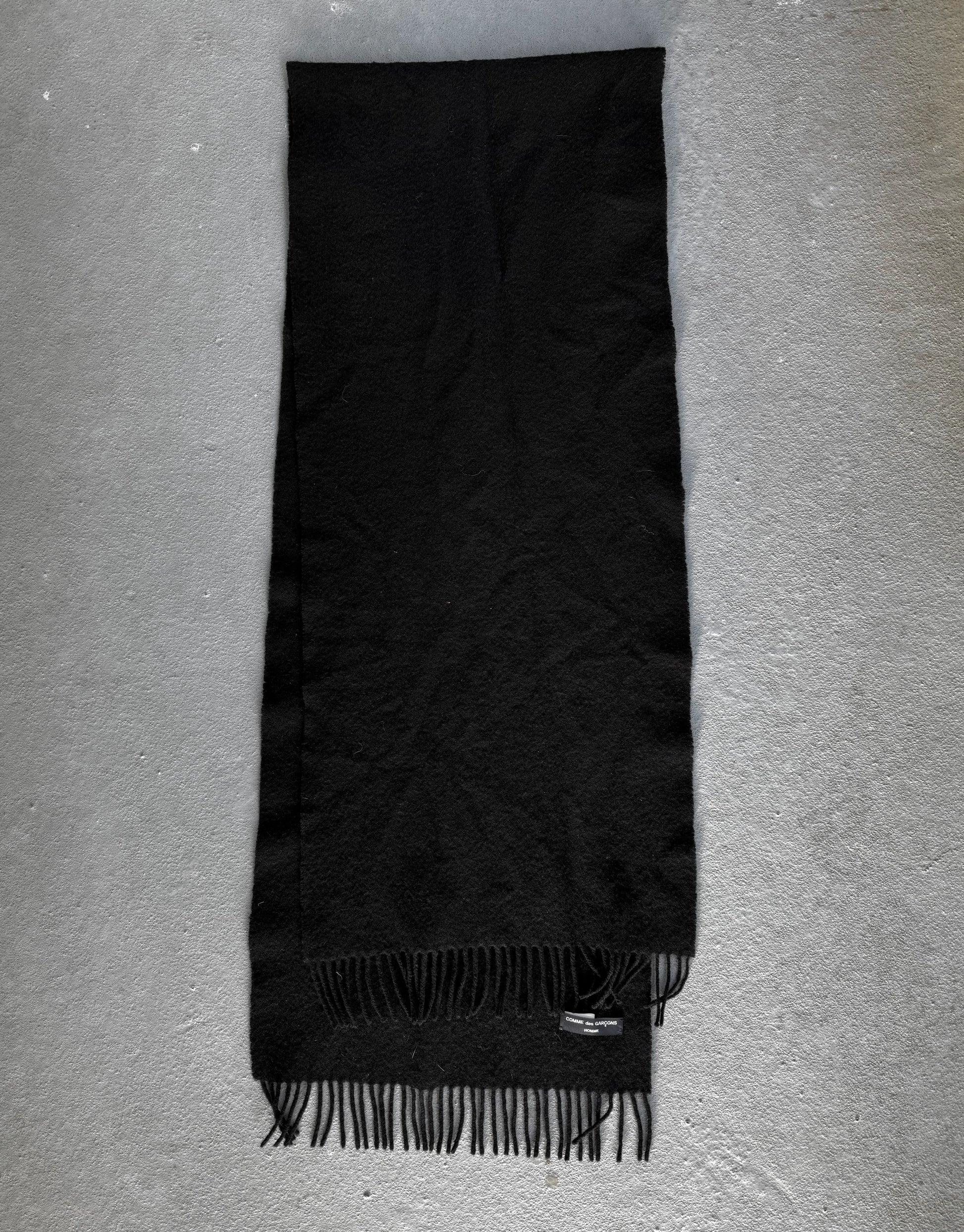 Black scarf with fringes on a gray background