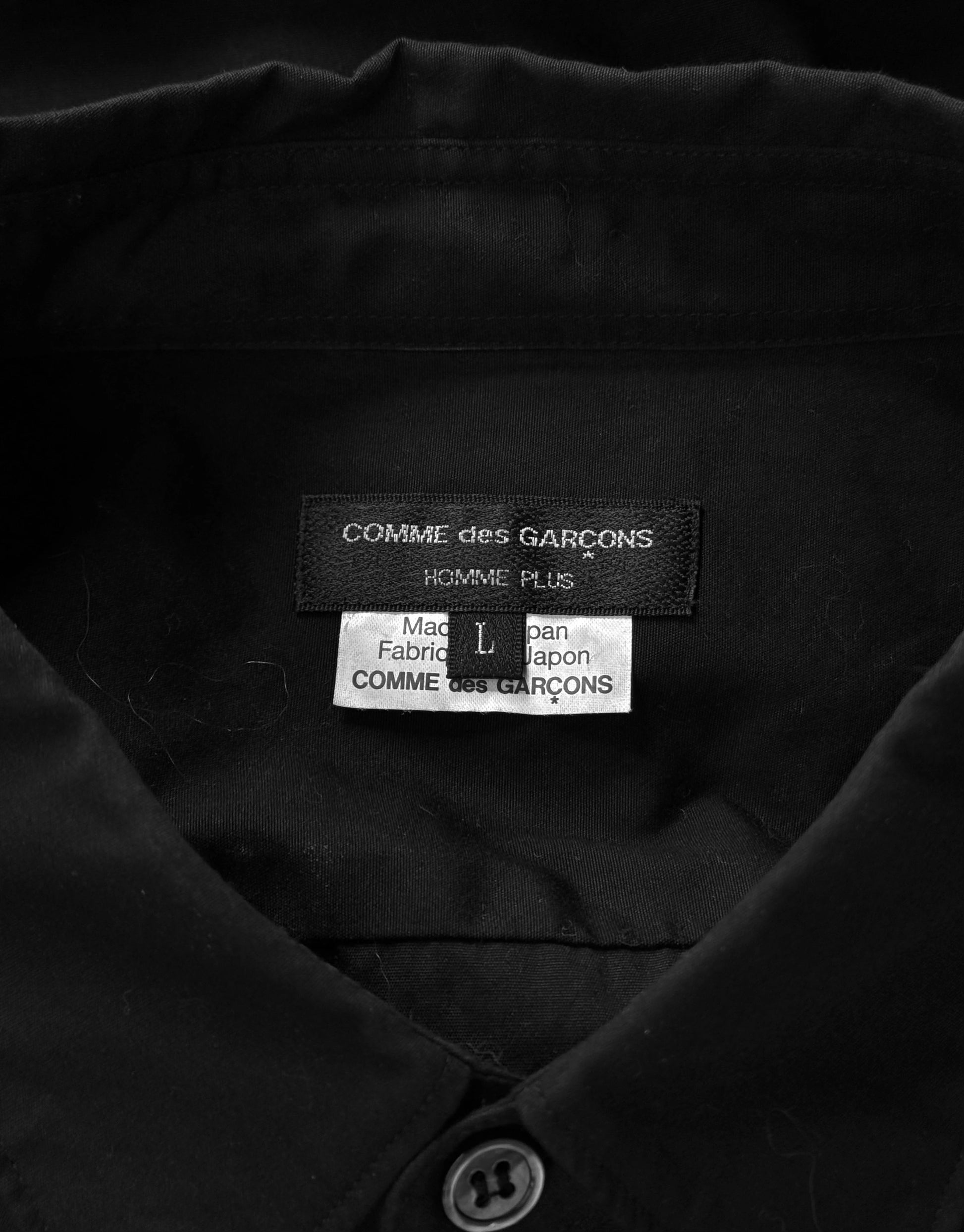 Black jacket with Comme des Garçons label on a dark background