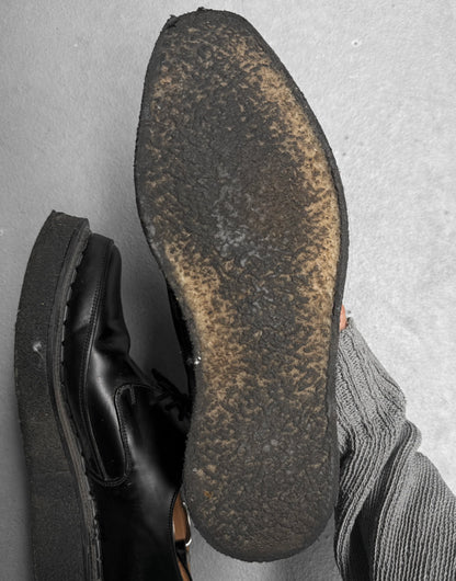 Close-up of a worn black shoe sole on a gray surface