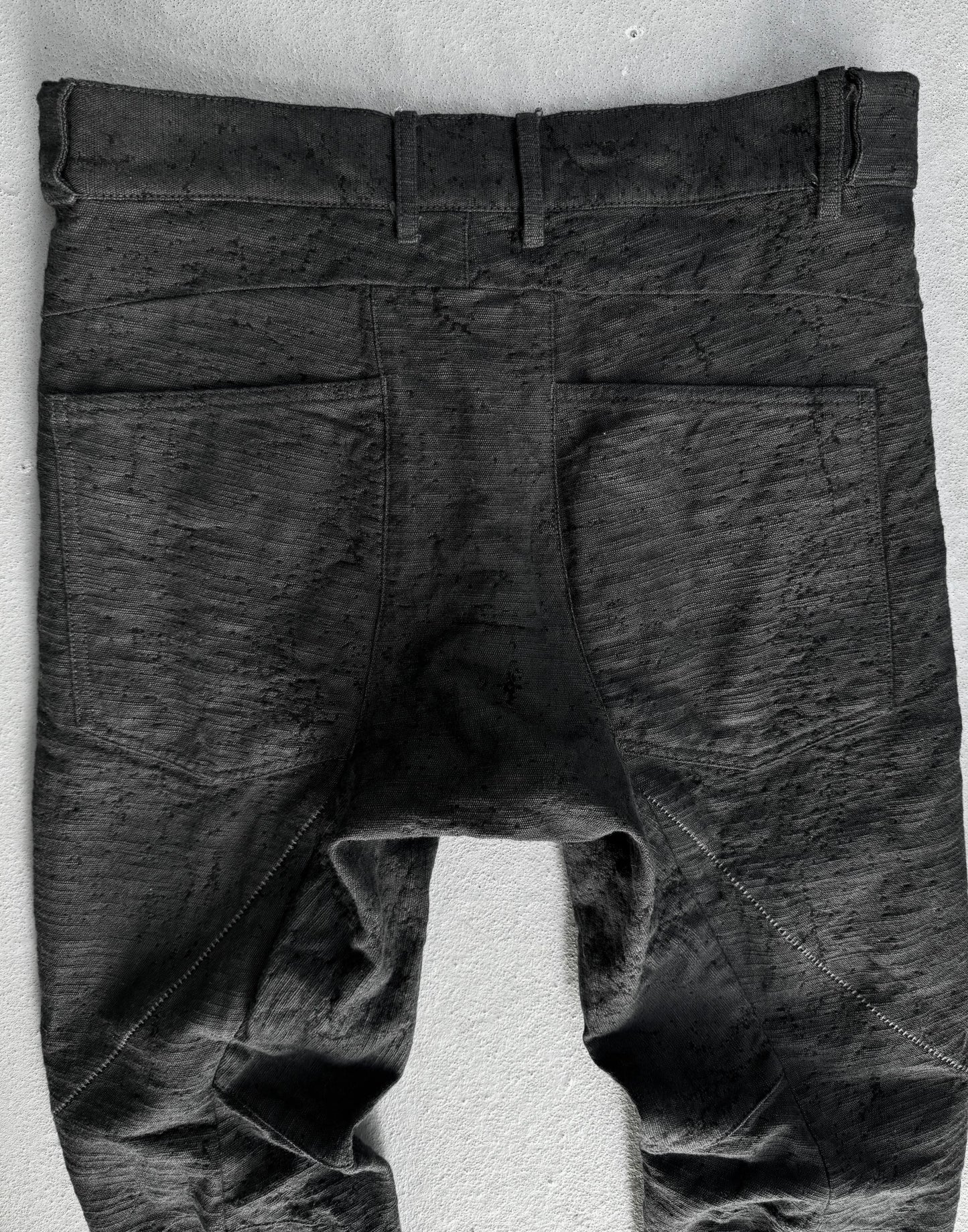 Dark gray pants on a white stand against a light gray background