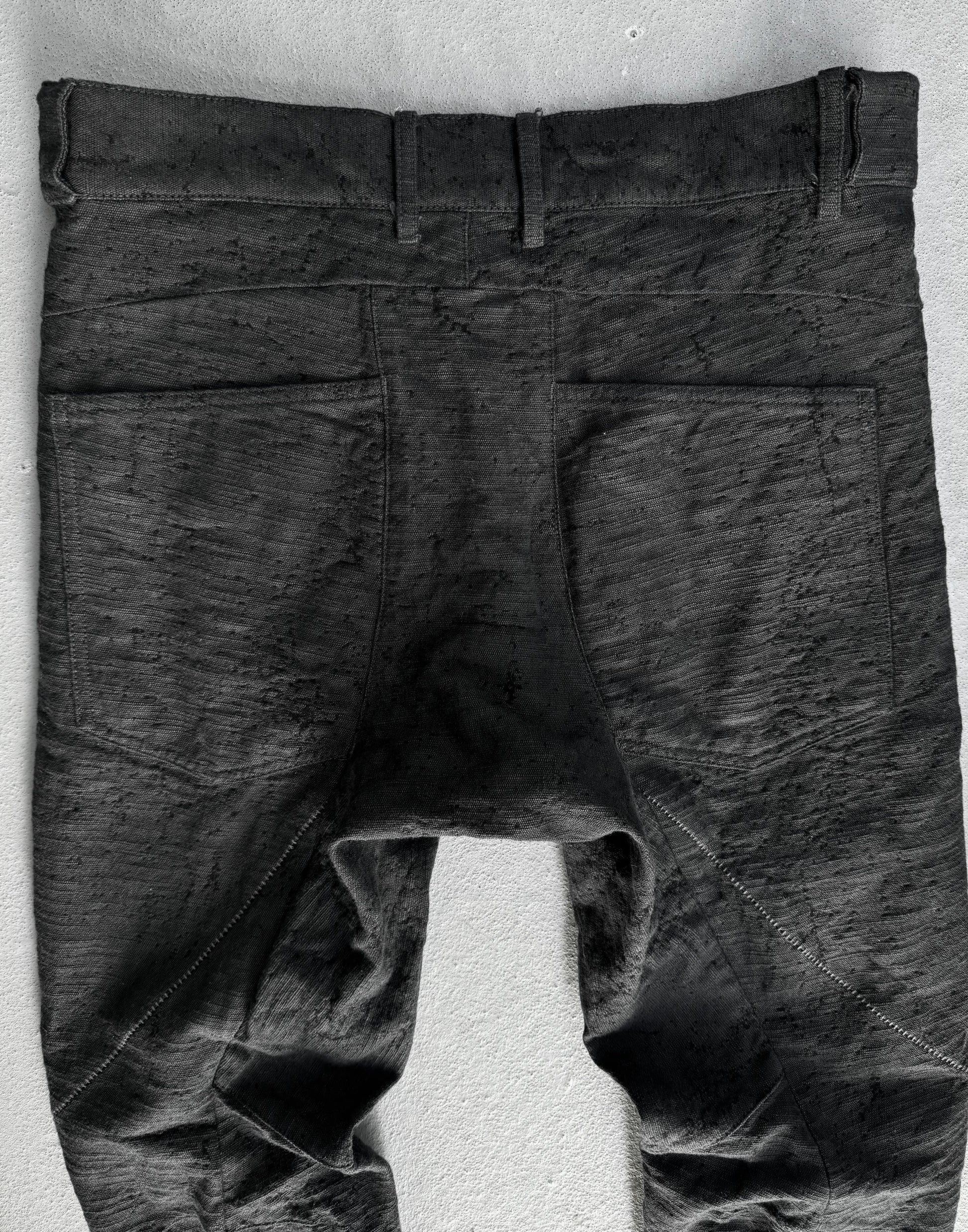 Dark gray pants on a white stand against a light gray background