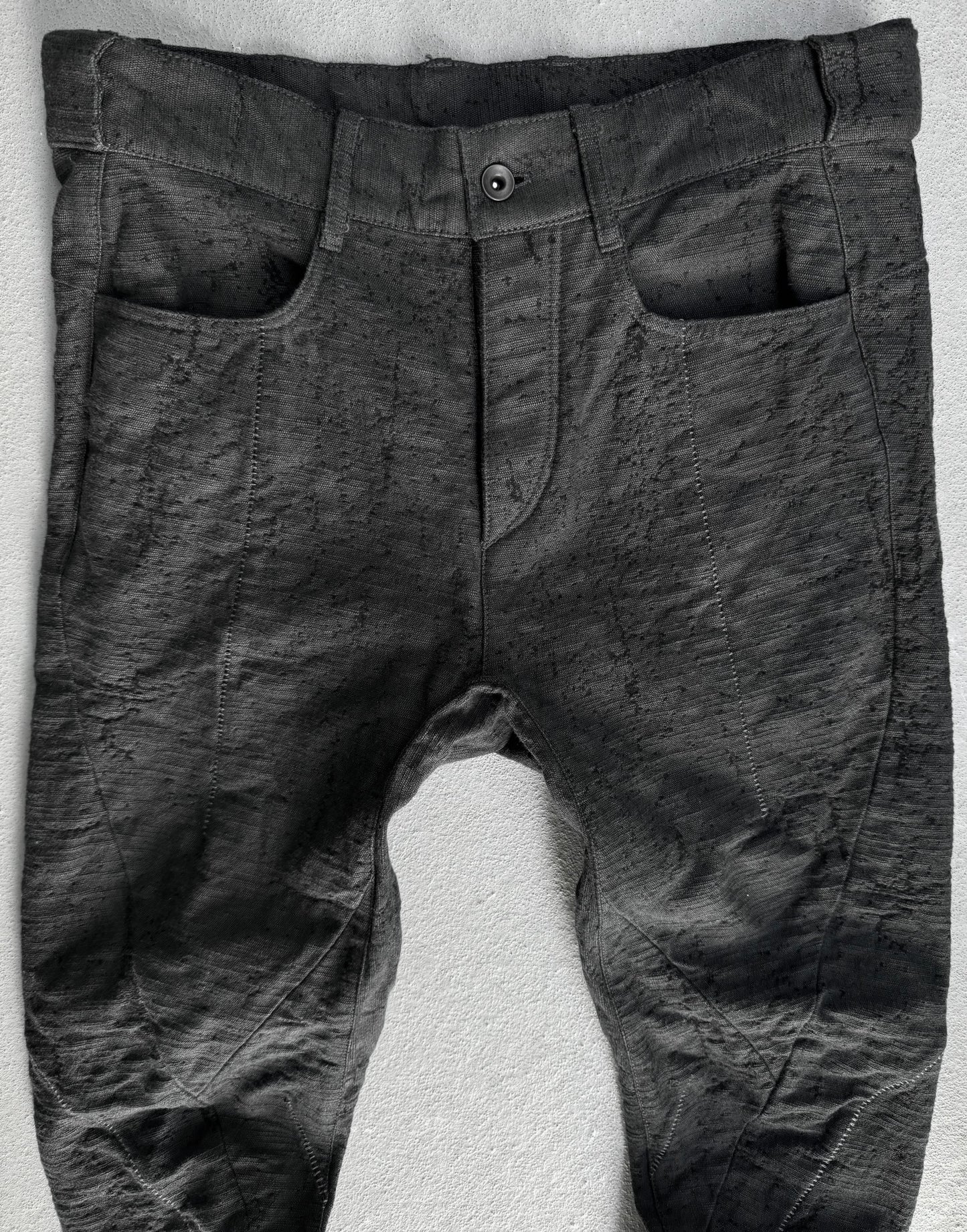 Dark gray pants on a textured white surface