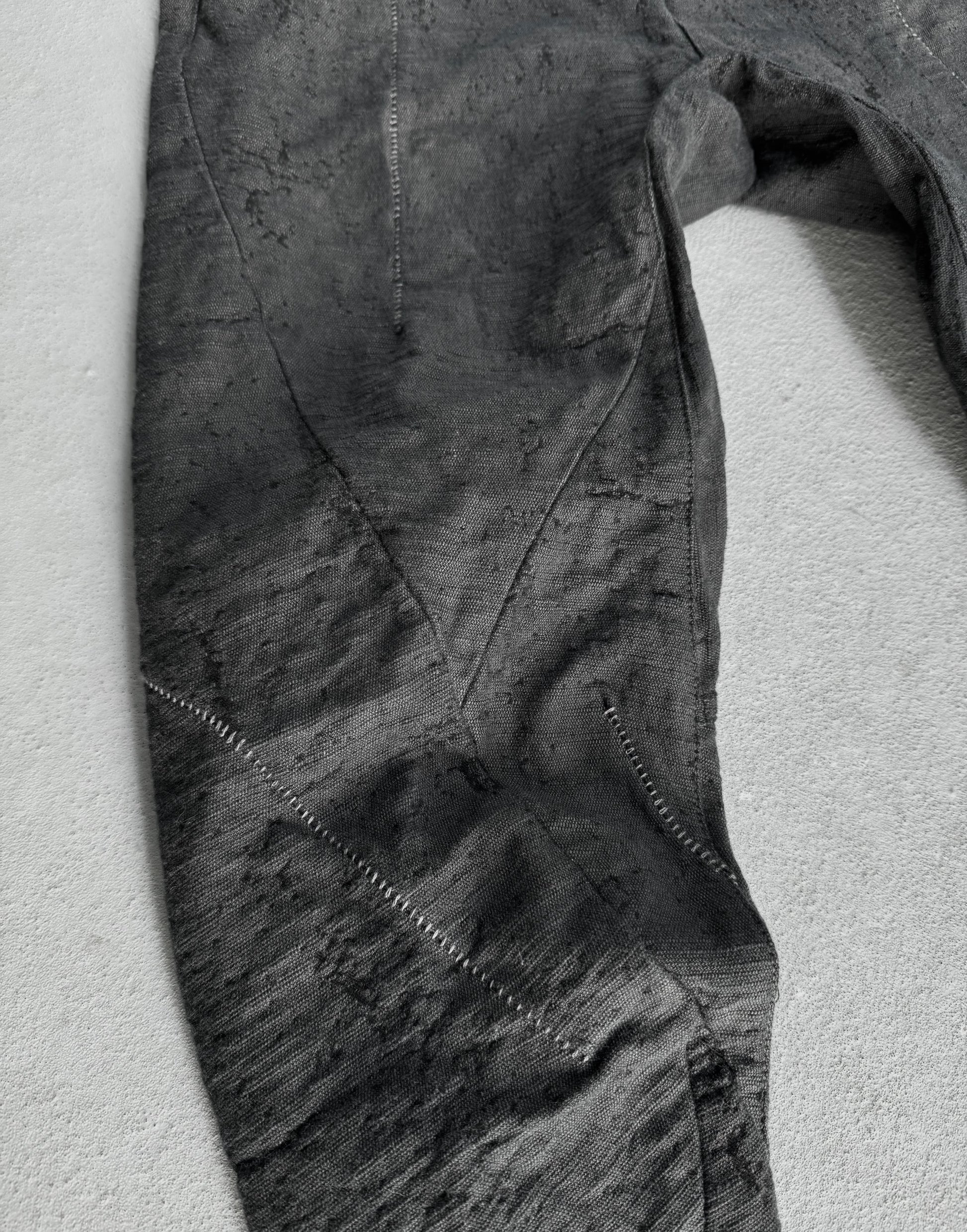 Close-up of a textured gray fabric with visible stitching on a light gray background