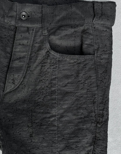 Close-up of dark gray pants with a pocket on a light gray background