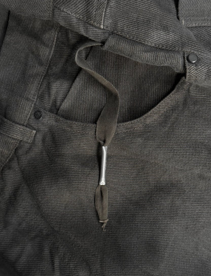 Close-up of a dark gray jacket with a drawstring and buttons.