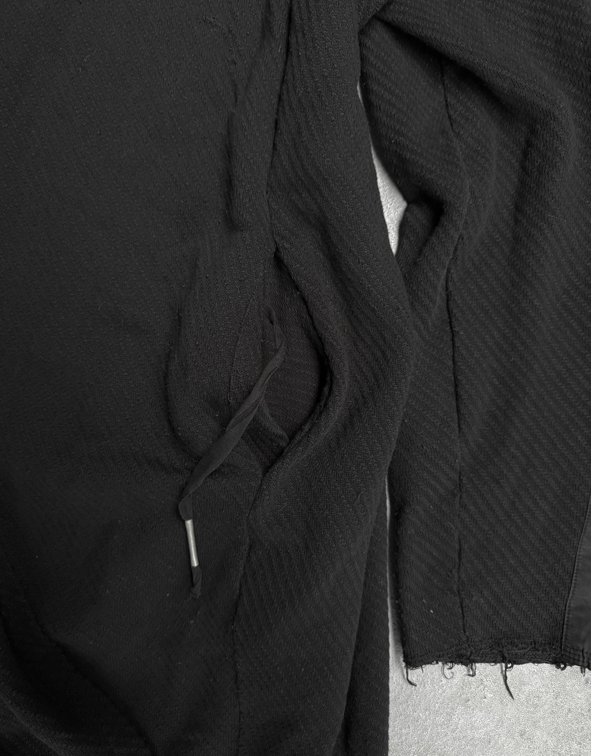 Close-up of a black textured fabric with a visible seam on a dark background
