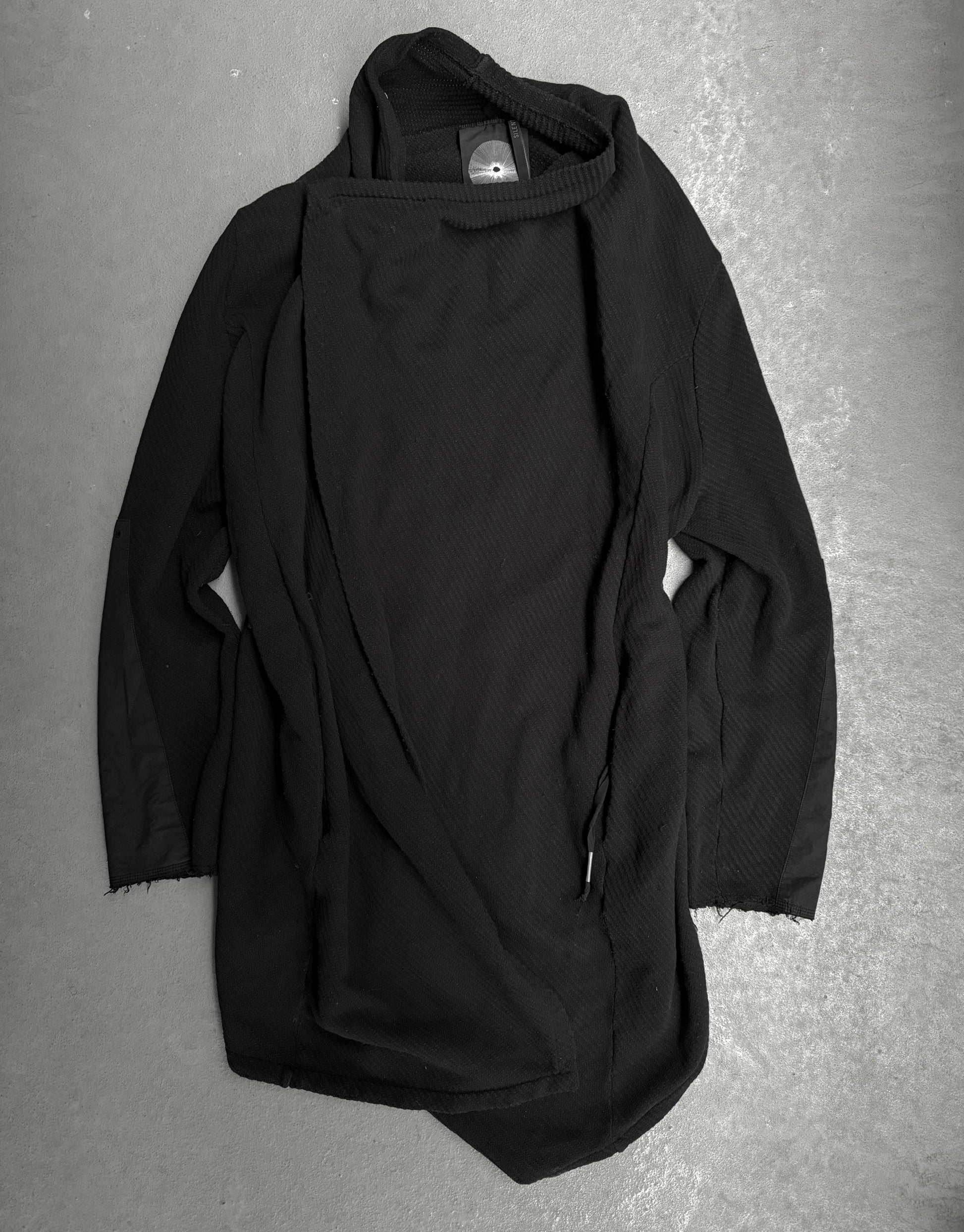 Black hooded garment on a gray surface