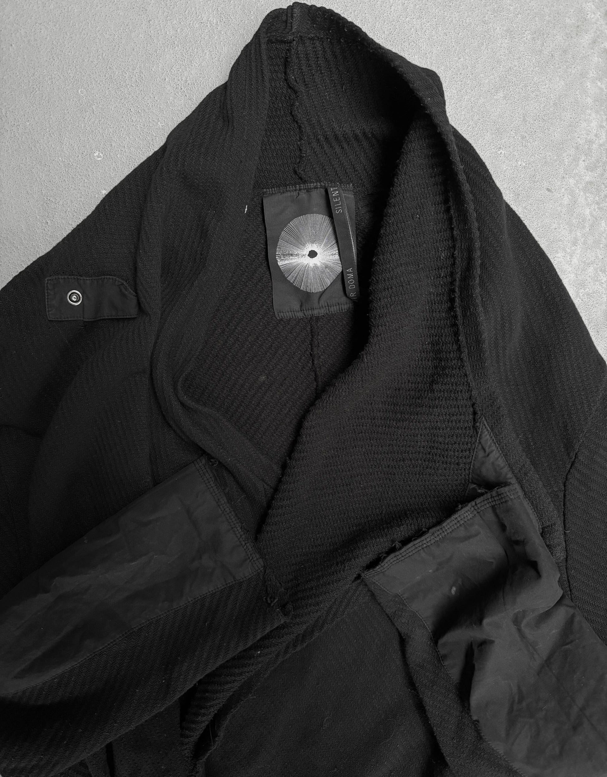 Close-up of a black jacket with a brand label on a gray background