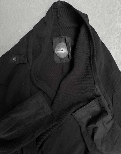 Close-up of a black jacket with a brand label on a gray background