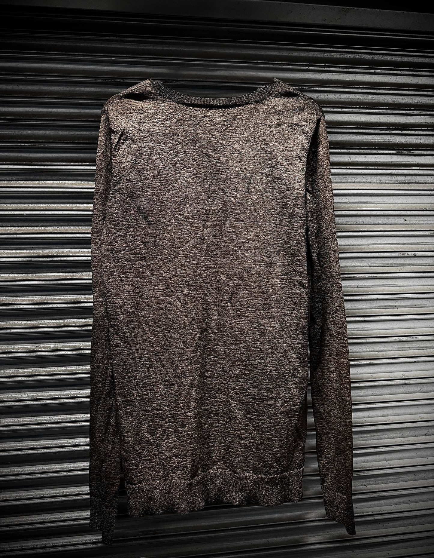 Brown textured sweater on a metallic surface