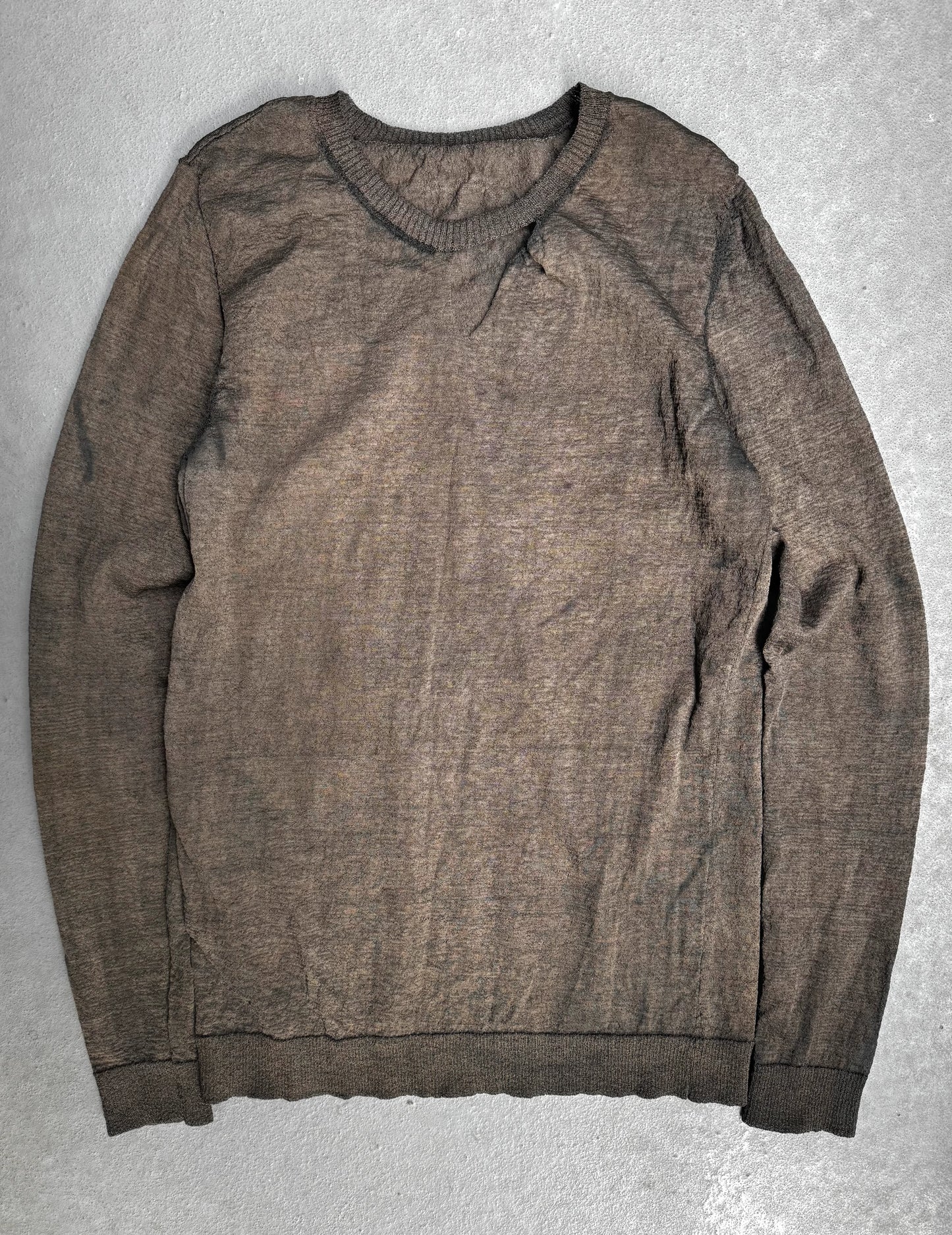 Brown sweater on a gray textured surface