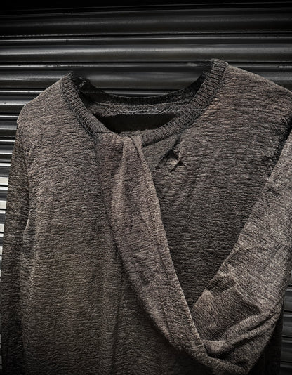 Dark gray textured sweater on a hanger against a black background