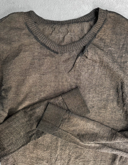 Brown sweater on a textured gray background