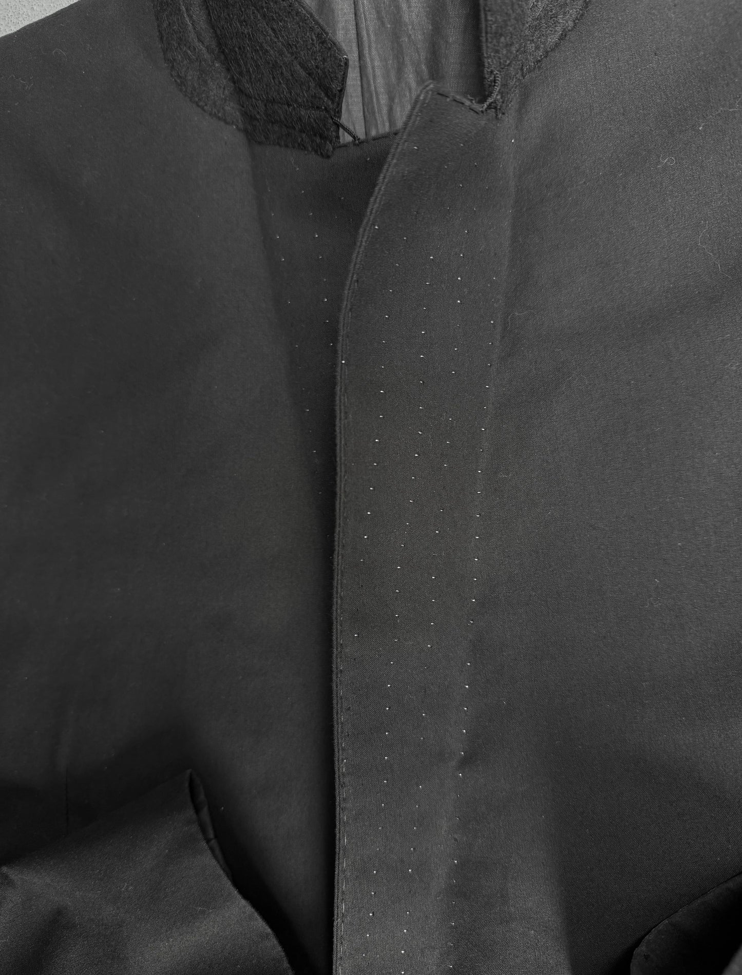 Close-up of a dark gray jacket with a collar and lapel.
