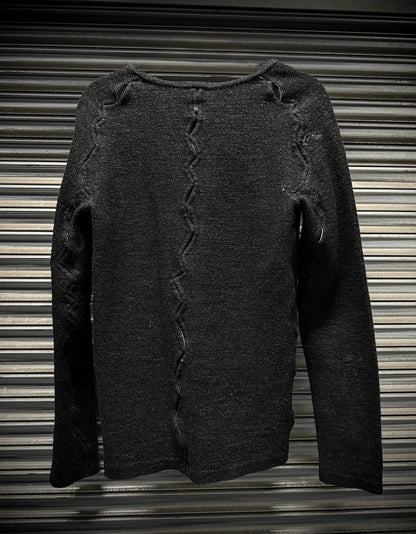 Dark gray sweater with distressed details on a corrugated metal background