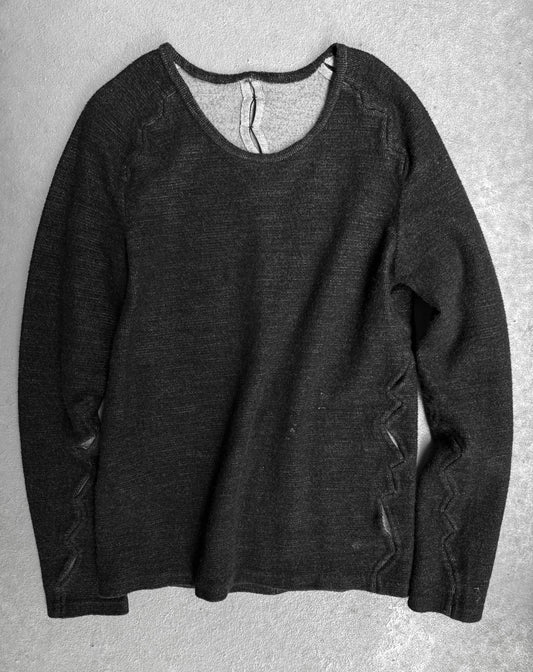 Dark gray sweater on a textured gray surface
