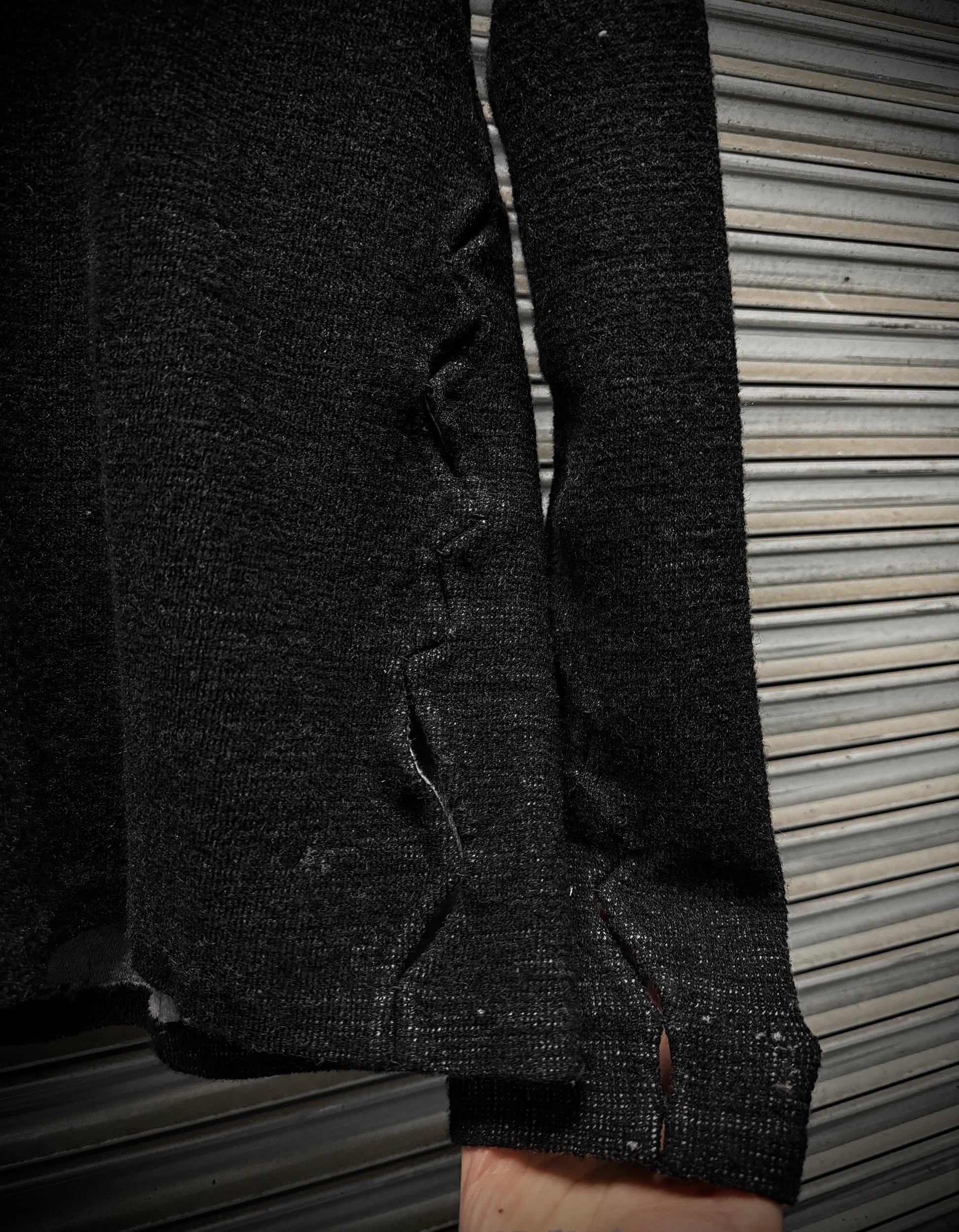 Close-up of a dark textured fabric with a zipper on a wooden surface