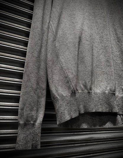 Gray sweater draped over a metallic surface
