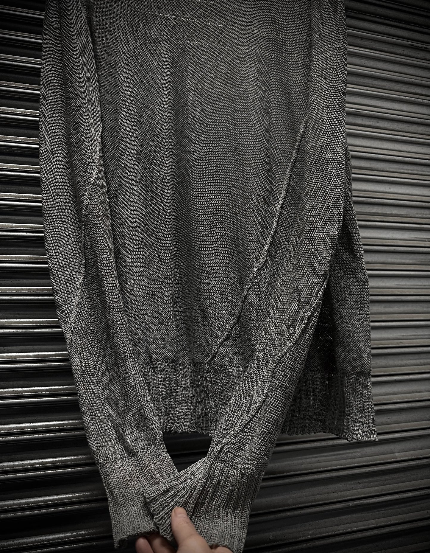 Gray textured fabric draped over a metallic surface