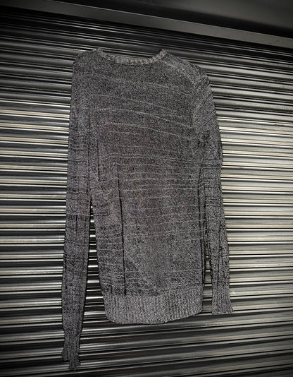 Gray sweater hanging against a metallic background