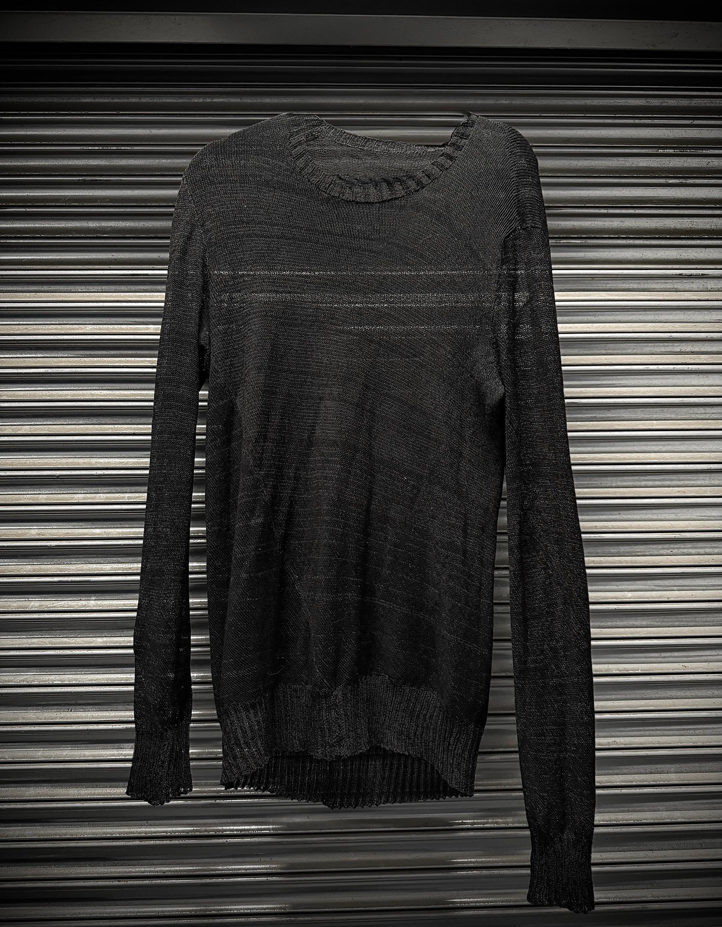 Dark gray sweater on a striped background