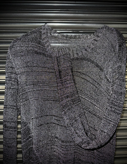Gray textured sweater on a hanger against a metallic background