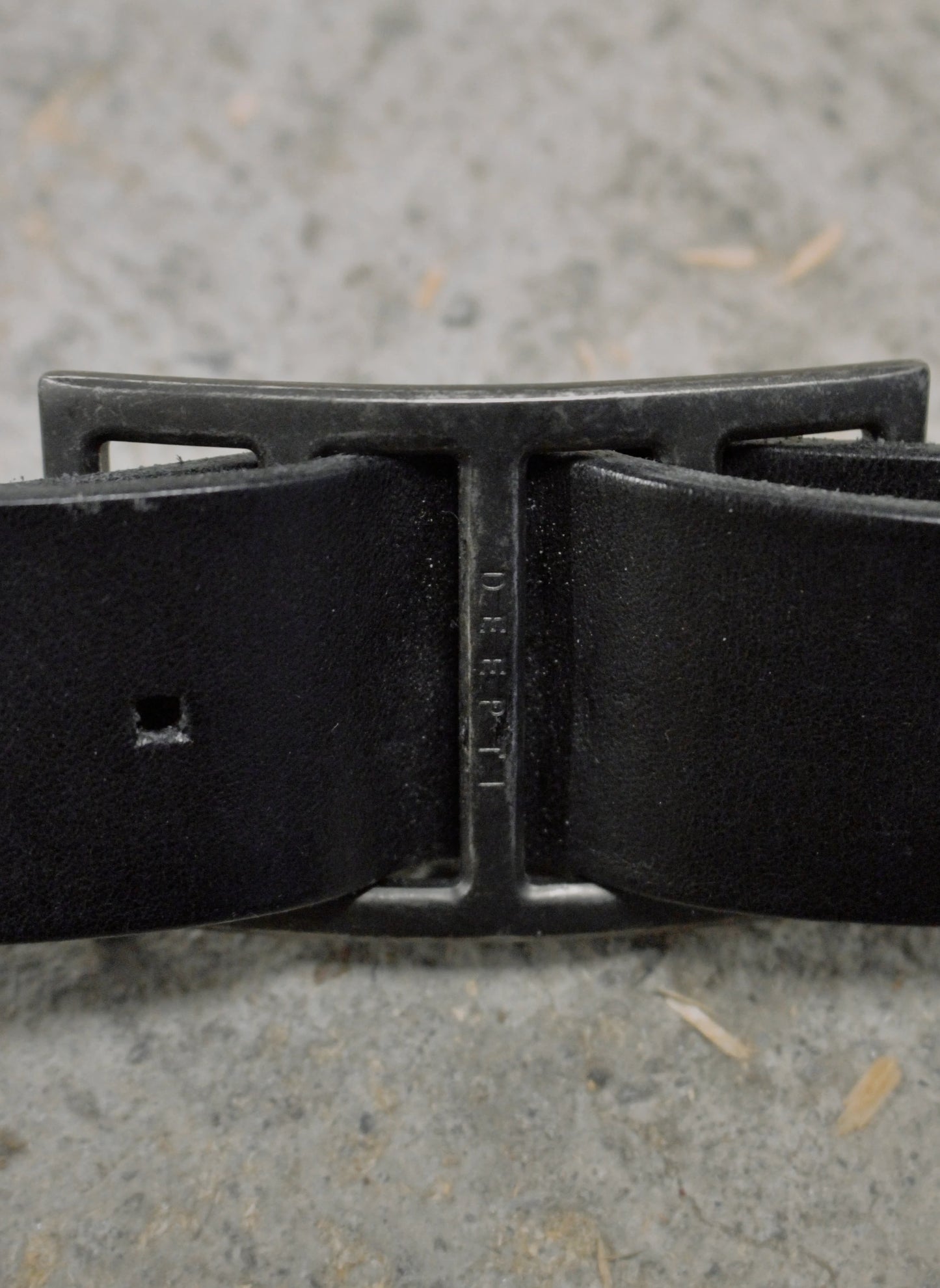 Black belt with a metal buckle on a textured surface