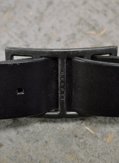Black belt with a metal buckle on a textured surface