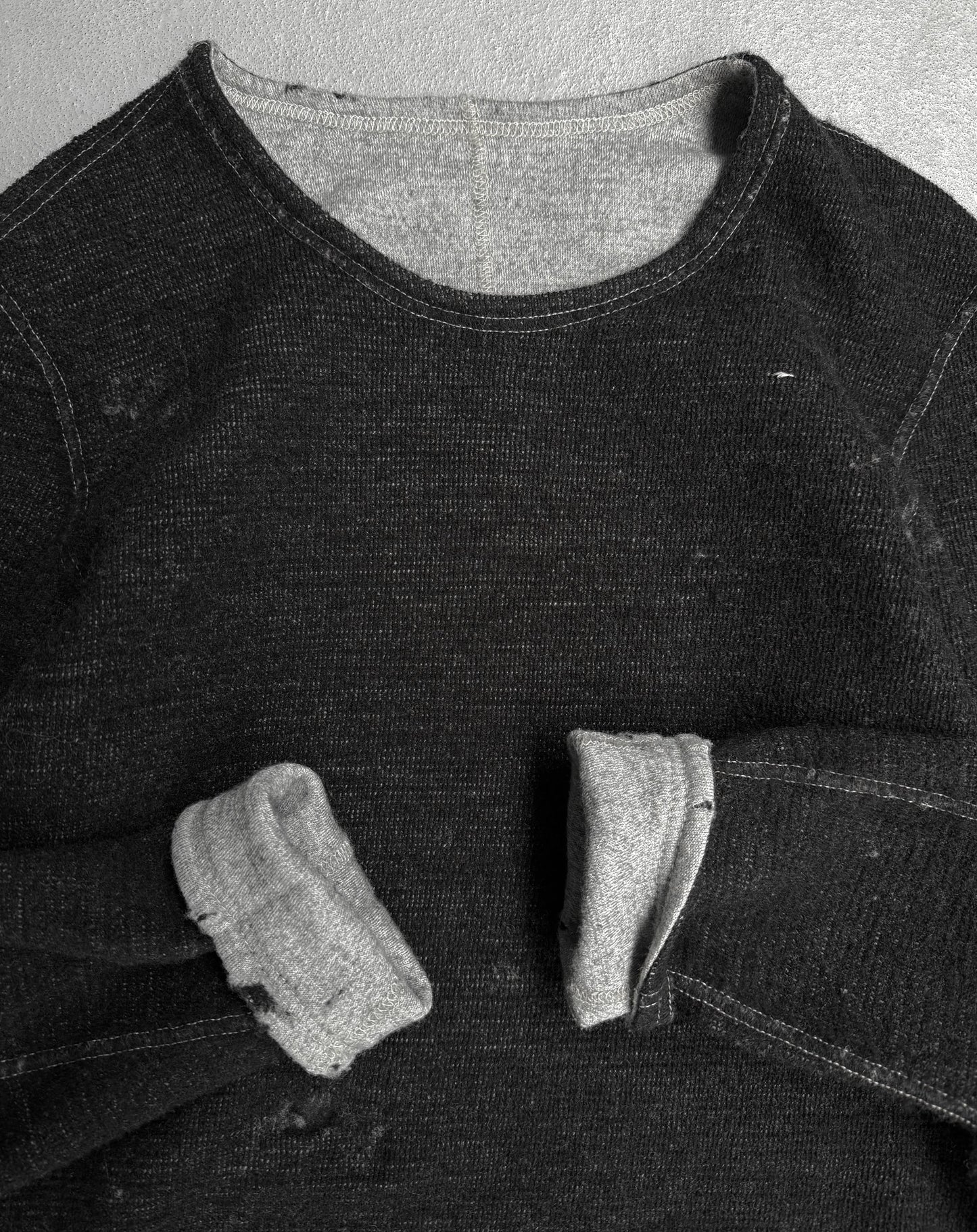 Black denim shirt with a pocket on a textured gray background