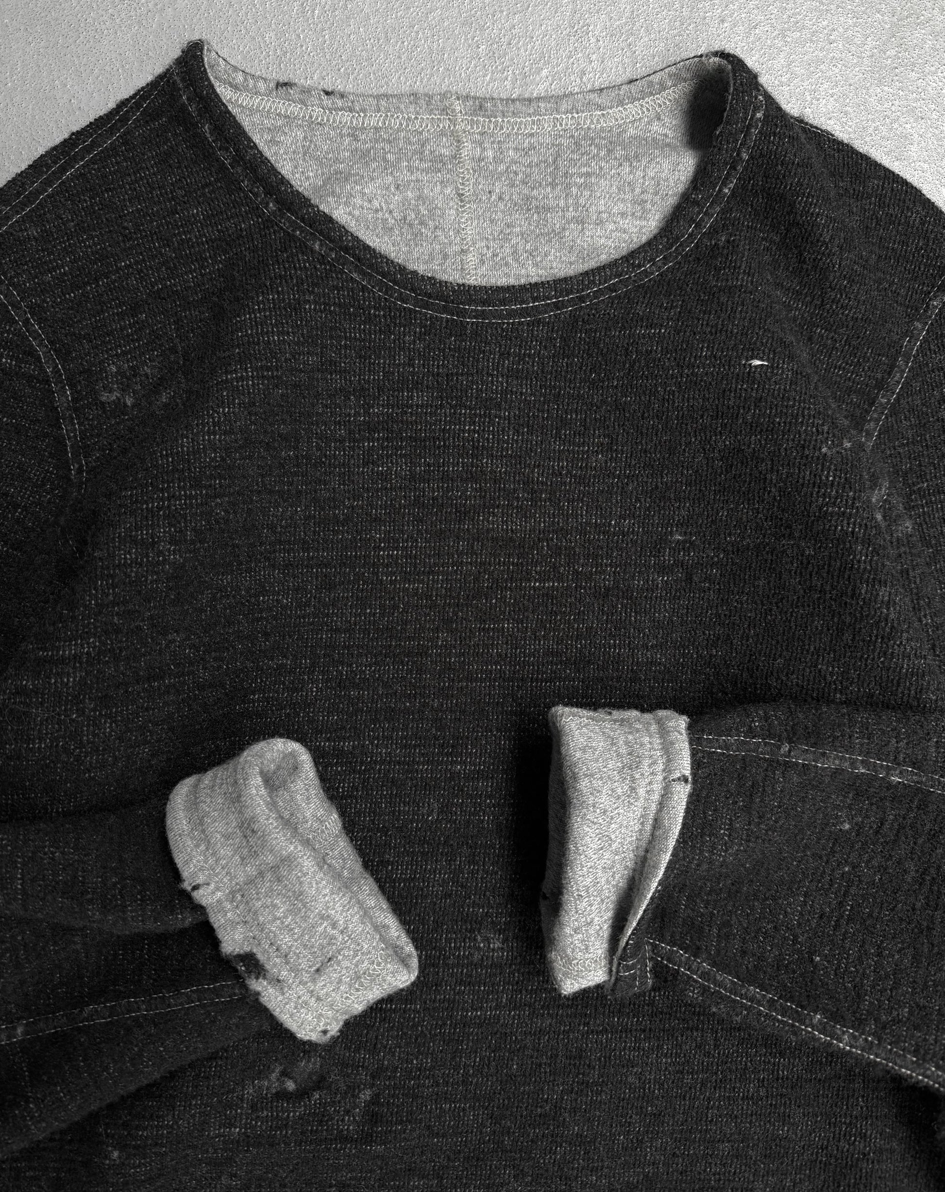 Black denim shirt with a pocket on a textured gray background