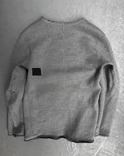 Gray sweater with a black patch on a gray background