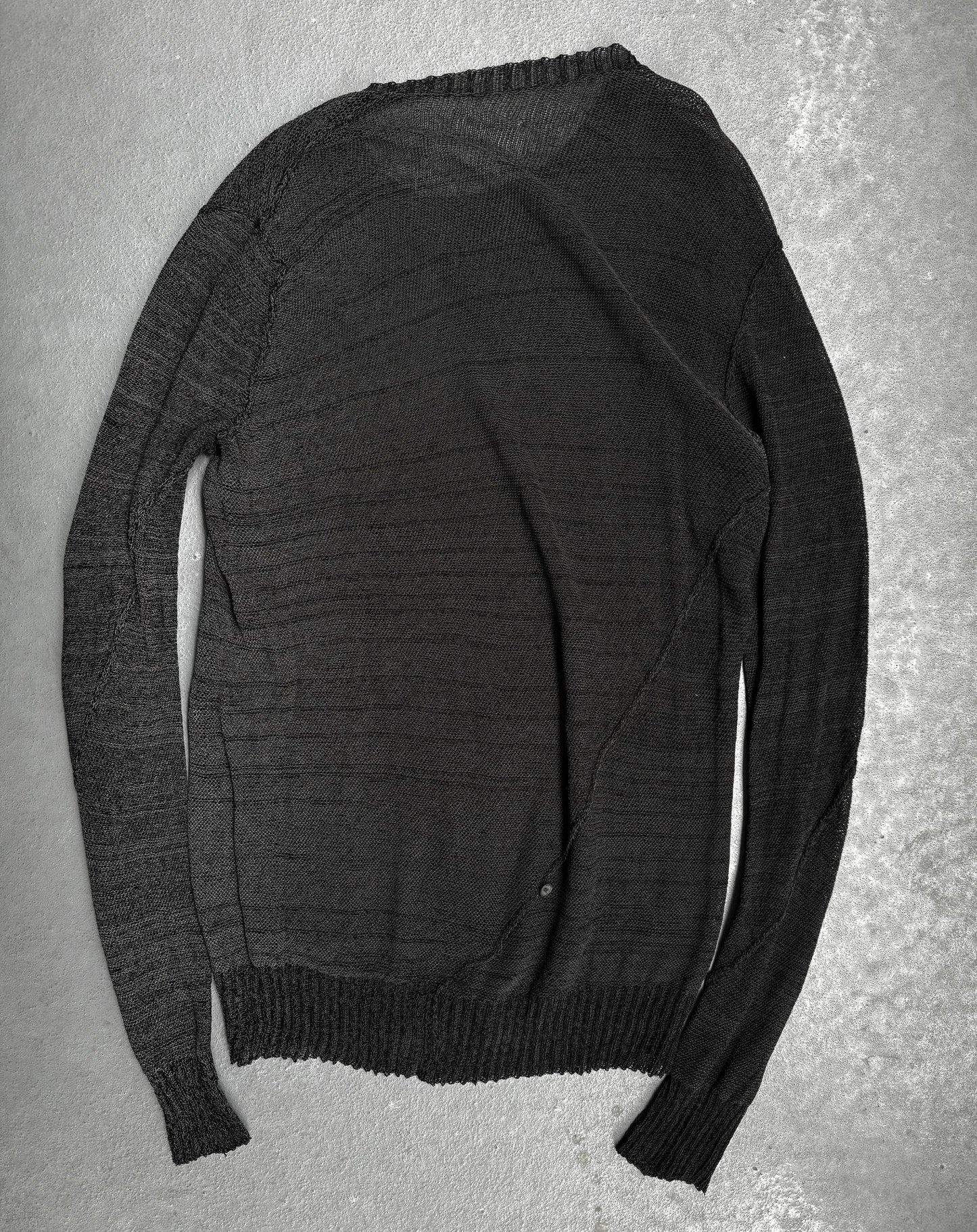 Dark gray sweater on a textured gray surface