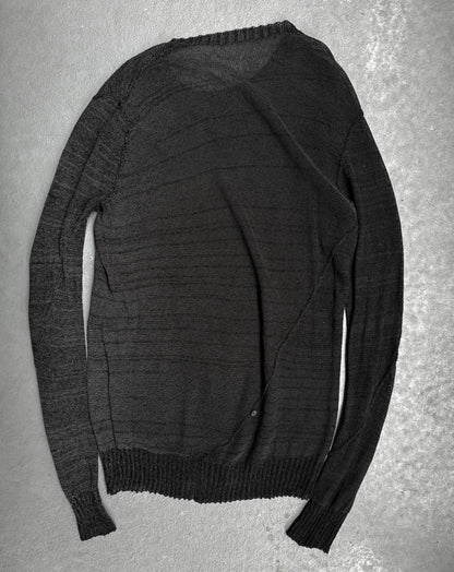 Dark gray sweater on a textured gray surface
