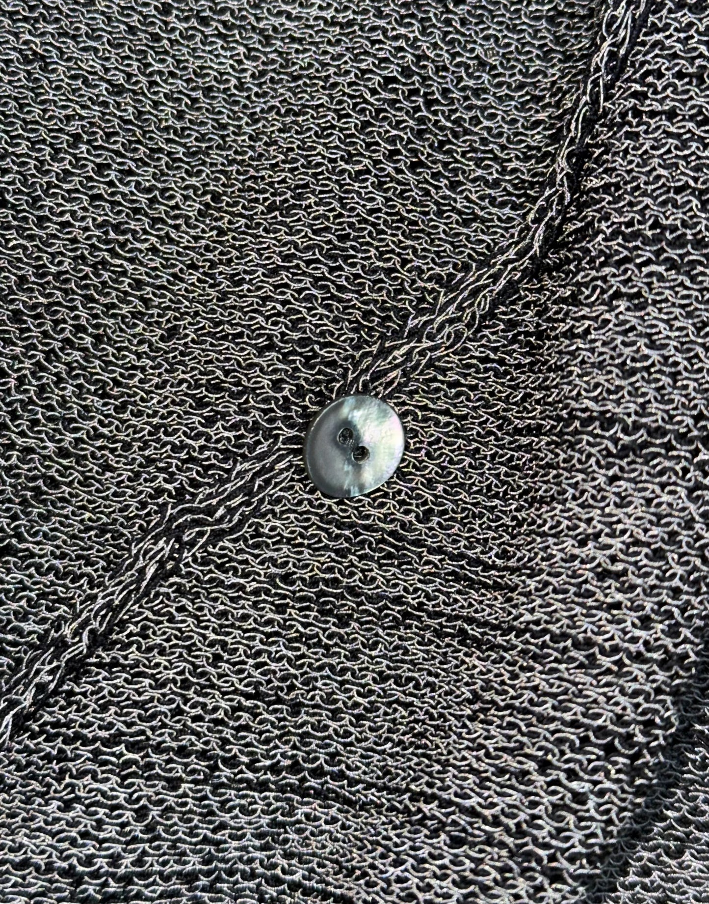 Close-up of a textured surface with a chain and round object.