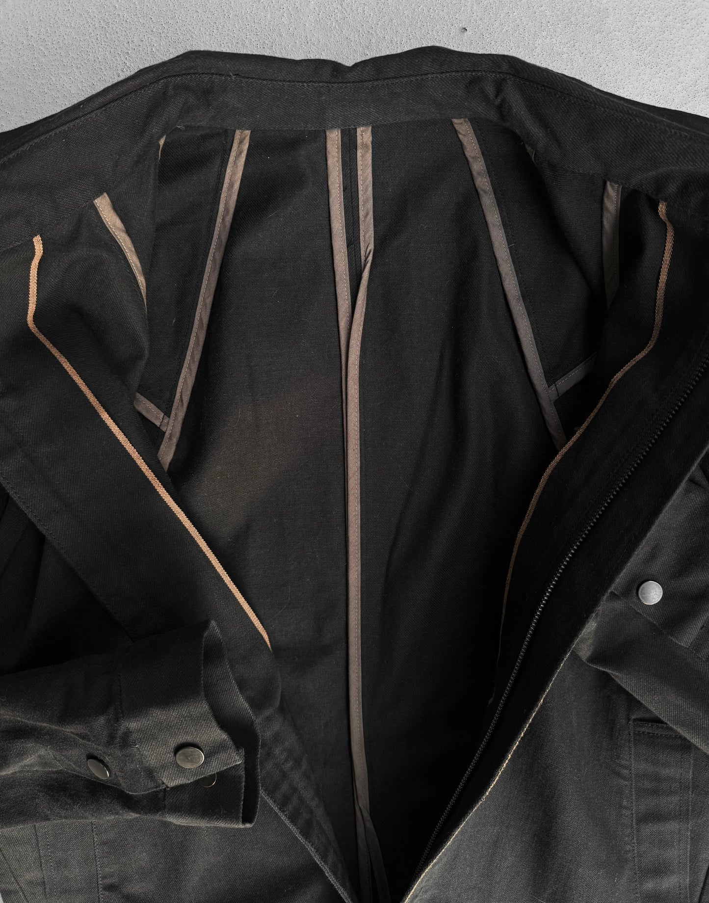 Black jacket with brown accents on a gray background