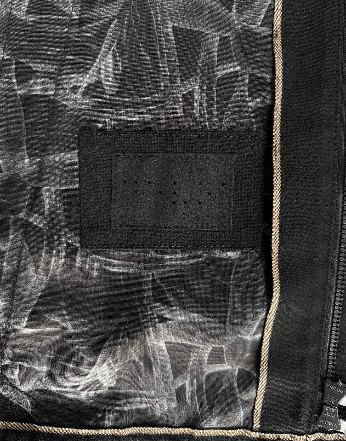 Close-up of a black and white patterned fabric with a textured label.