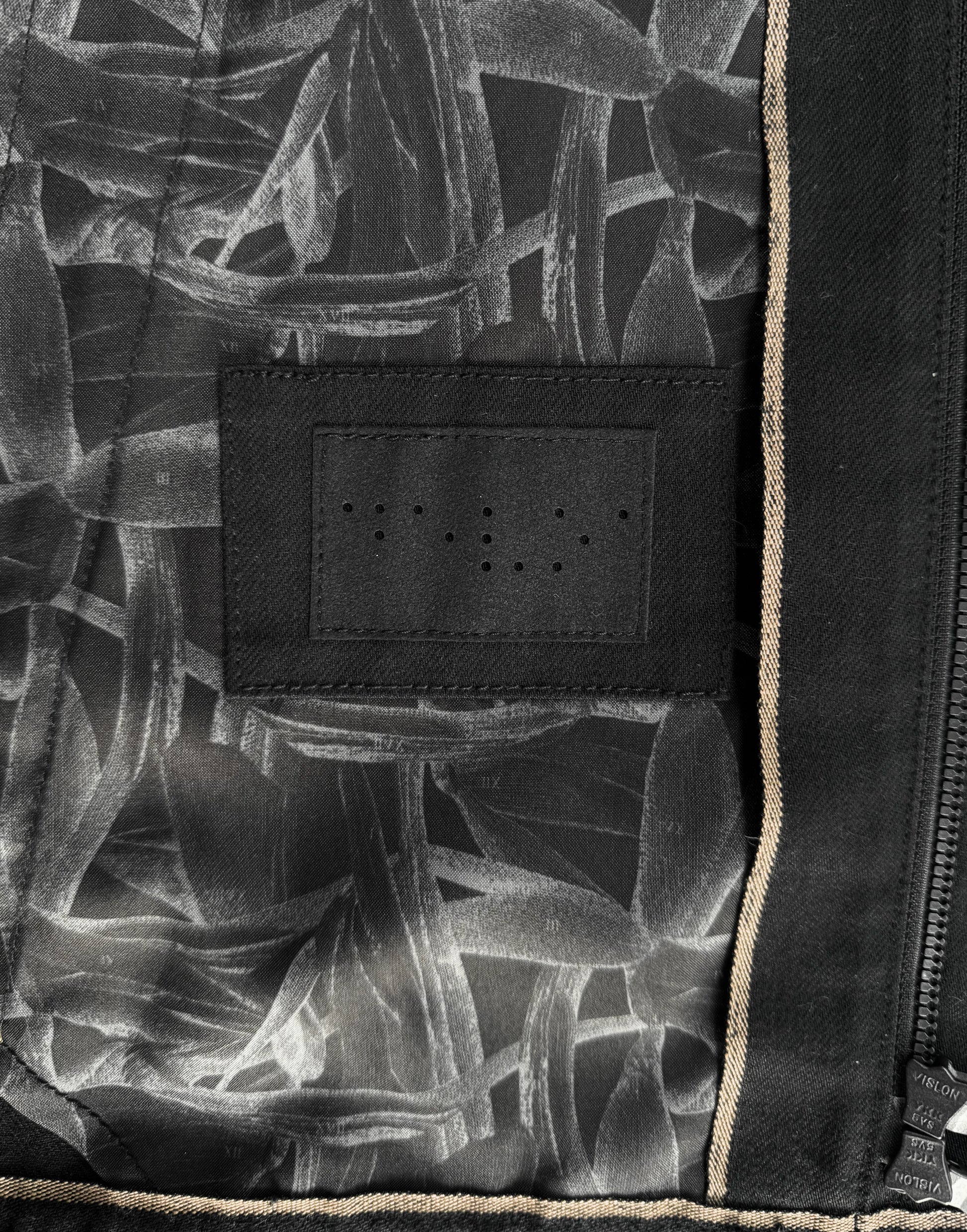Close-up of a black and white patterned fabric with a textured label.