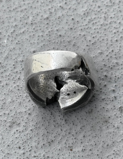 Silver ring with a unique design on a textured gray surface