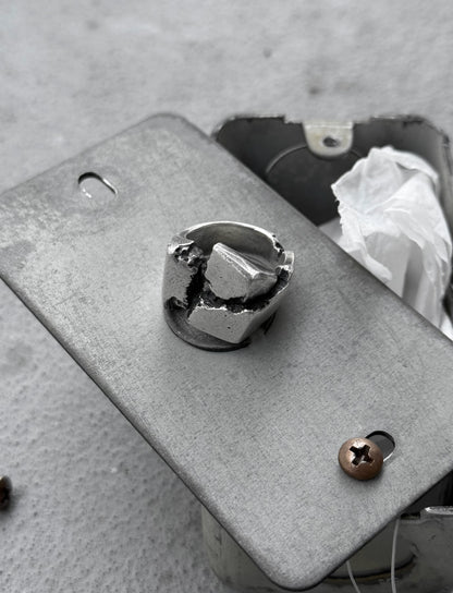Metallic object with a central component on a textured surface