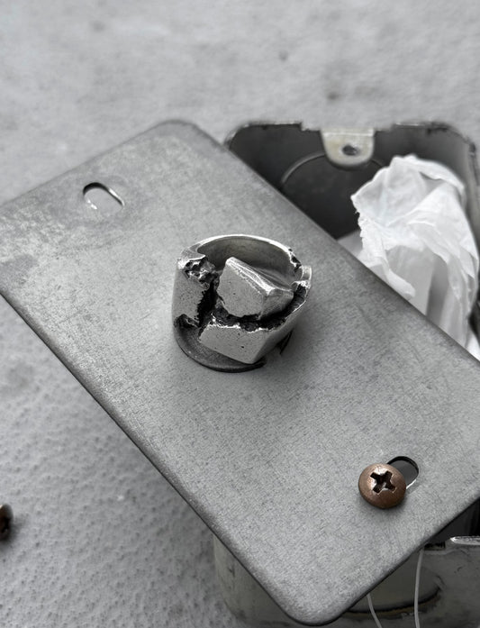 Metallic object with a central component on a textured surface