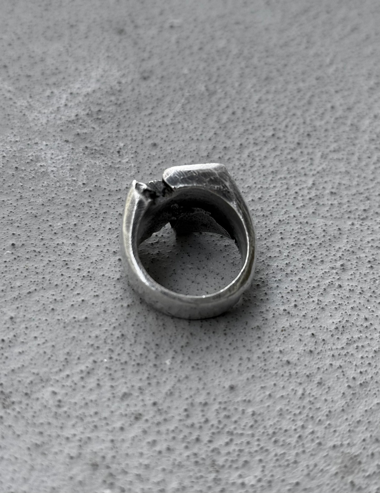 Silver ring on a textured gray surface