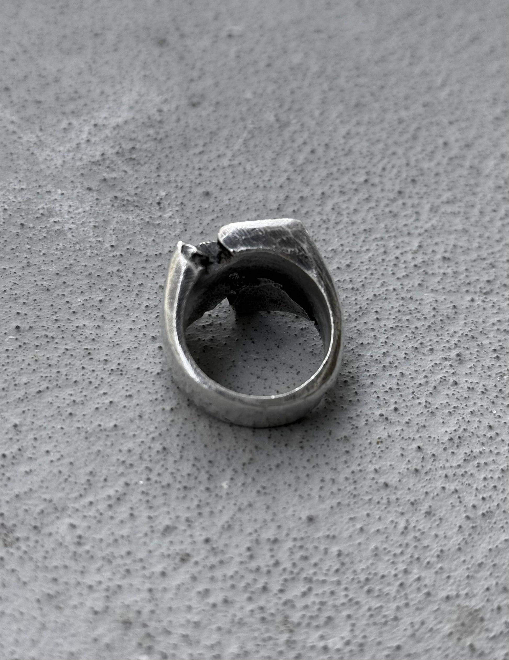 Silver ring on a textured gray surface