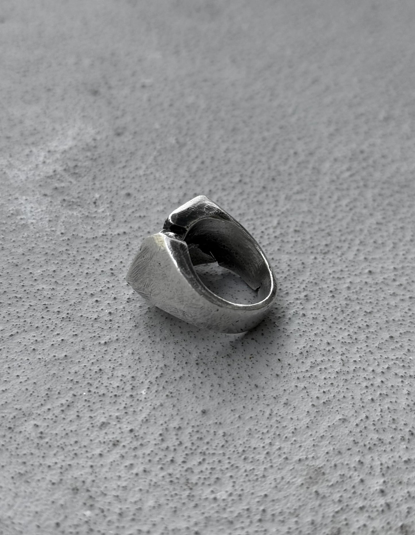 Silver ring on a textured gray surface
