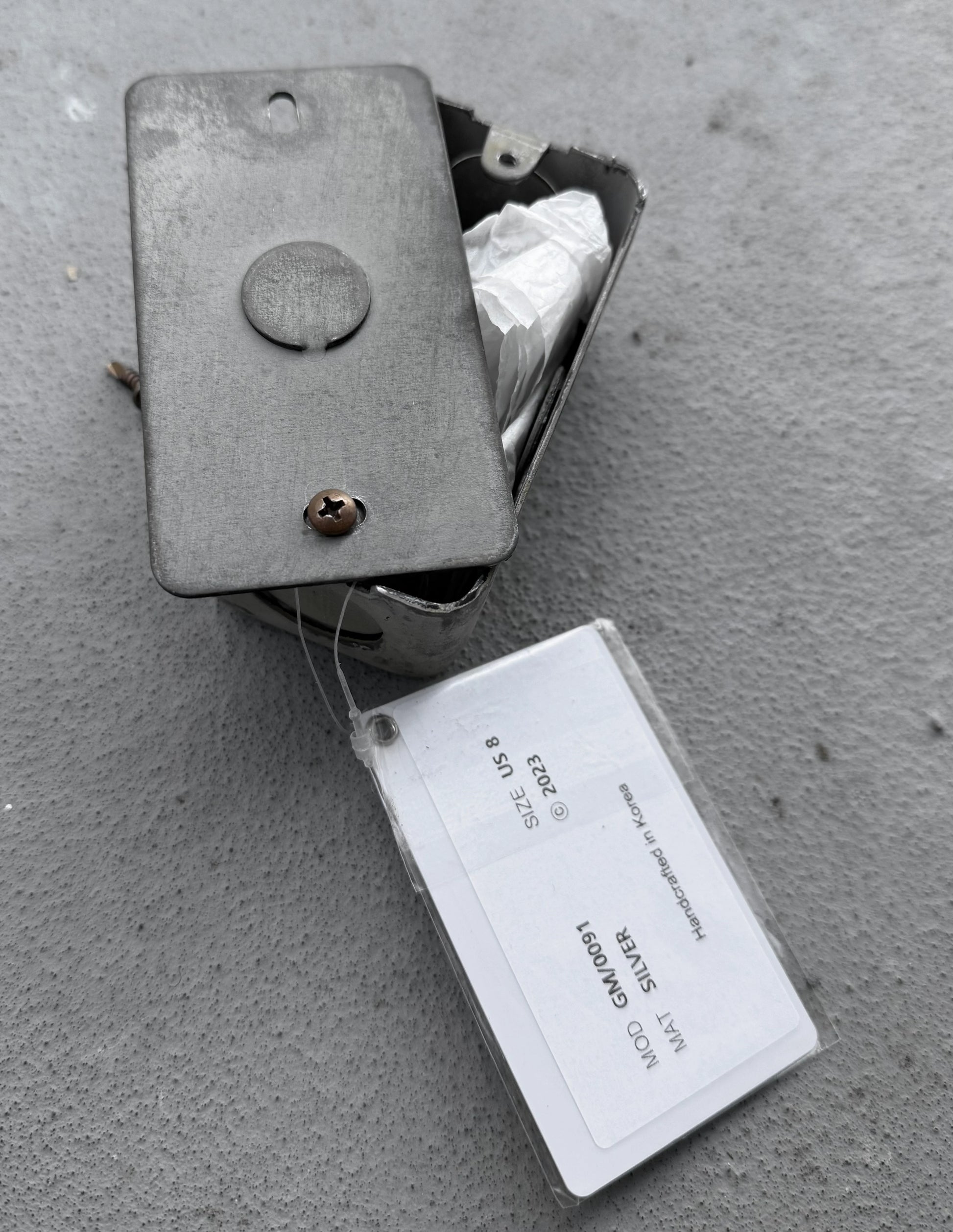 Metal box with a label on a concrete surface