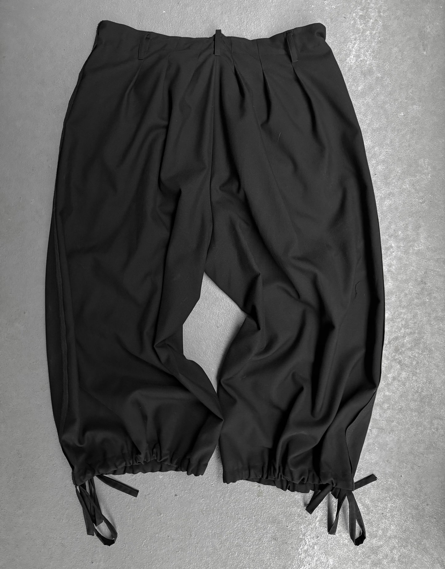 Black pants with drawstring on a gray background