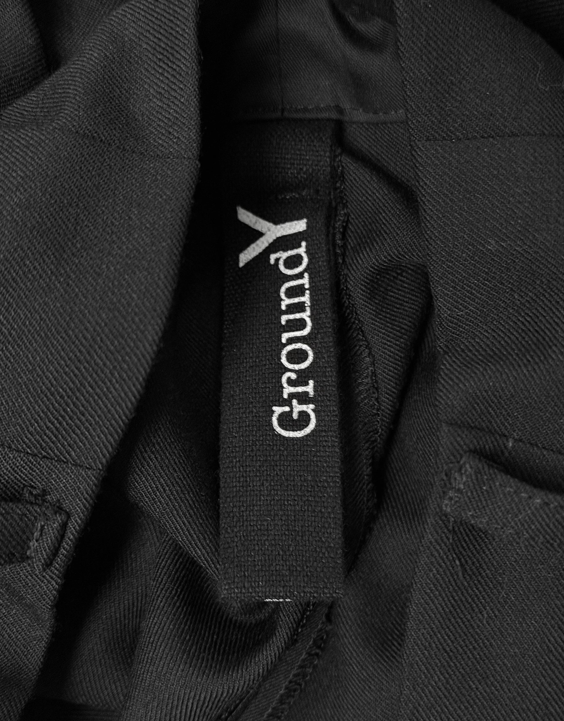 Close-up of a black jacket with 'GroundY' logo on a dark background